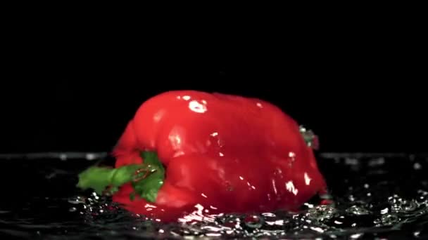 Super cámara lenta en el agua con salpicaduras flota un pimiento rojo. Filmado en una cámara de alta velocidad a 1000 fps. — Vídeos de Stock