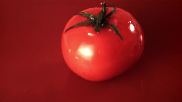 Super slow motion hele tomaat valt in tomatensap met spatten. Gefilmd met 1000 fps. — Stockvideo