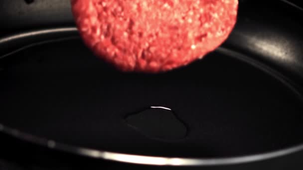 Super slow motion sulla padella cade un hamburger crudo con una spruzzata di burro. Girato su una telecamera ad alta velocità a 1000 fps. — Video Stock