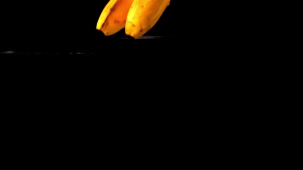 Super zpomalené čerstvé banány padají do vody s cákáním. Natočeno při 1000 snímcích za sekundu. — Stock video