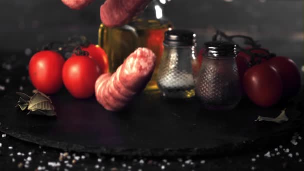 Super zpomalený film na kamenné desce s rajčaty a kořením padajícími syrovými klobásami. Natočeno na vysokorychlostní kameře rychlostí 1000 snímků za sekundu. — Stock video