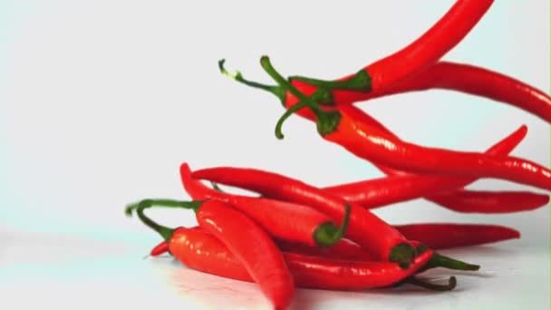 Super zpomalení červená pálivá chilli paprika padá na stůl. Natočeno na vysokorychlostní kameře rychlostí 1000 snímků za sekundu. — Stock video