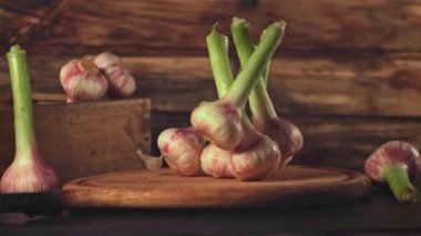 Süper yavaş çekimde sarımsak tahta bir arka planda kesim tahtasına düşer. 1000 fps hızla yüksek hızlı bir kamerayla çekildi..