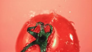 Olgun domatesin üzerinde süper yavaş çekim suyu düşürür. Çekim 1000 fps 'de..