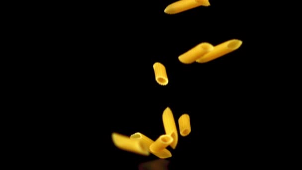 Super slow motion pasta penne torr faller på bordet. Inspelning på en höghastighetskamera vid 1000 fps. — Stockvideo