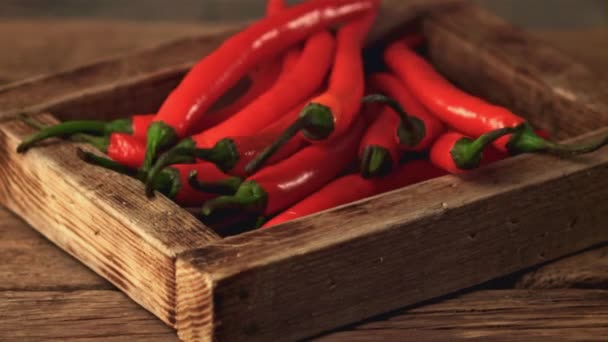 Super zpomalený tác s chilli paprikou padá na stůl. Natočeno na vysokorychlostní kameře rychlostí 1000 snímků za sekundu. — Stock video