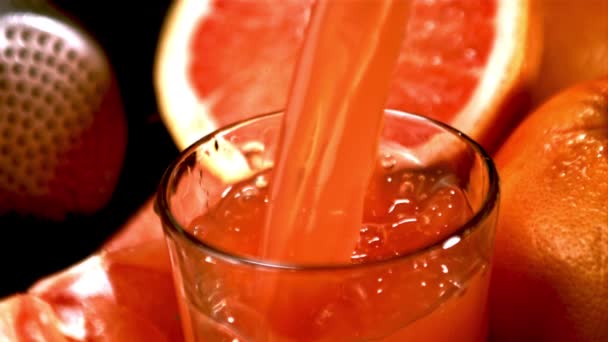 Superzeitlupe Grapefruitsaft ergießt sich über den Rand in das Glas. Gefilmt mit einer Hochgeschwindigkeitskamera bei 1000 fps. — Stockvideo