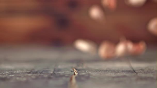 Knoblauchzehen fallen in Zeitlupe auf einen Holztisch. Gefilmt mit einer Hochgeschwindigkeitskamera bei 1000 fps. — Stockvideo