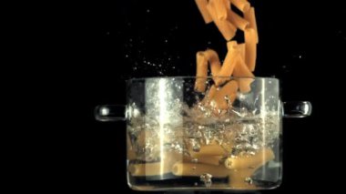 İçinde kaynar su dökülen makarna olan bir tavada süper yavaş çekim. 1000 fps hızla yüksek hızlı bir kamerayla çekildi..