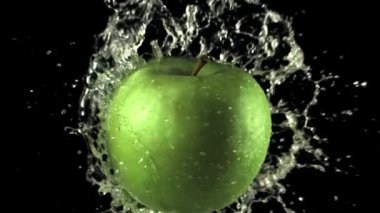 Süper yavaş çekim suyu elmanın üzerine su sıçratır. 1000 fps hızla yüksek hızlı bir kamerayla çekildi.