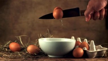 Çiğ yumurtanın süper yavaş hareketi keskin bir bıçakla kırılır. 1000 fps hızla yüksek hızlı bir kamerayla çekildi..