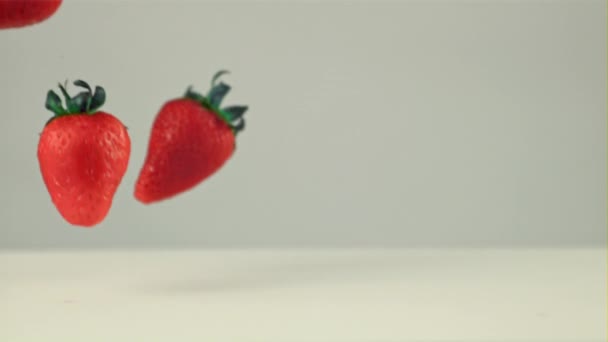 Super zpomalený film lahodné jahody padá do mléka s cákancemi. Natočeno na vysokorychlostní kameře rychlostí 1000 snímků za sekundu — Stock video