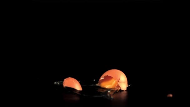 Super cámara lenta huevo crudo cae sobre la mesa y se rompe. Filmado en una cámara de alta velocidad a 1000 fps. — Vídeo de stock