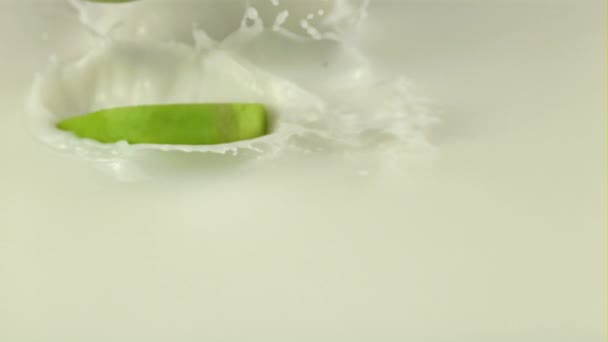 Super slow motion pieces of fresh apple fall into the milk with splashes. Filmed on a high-speed camera at 1000 fps — Stock Video