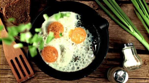 Les oignons verts hachés au ralenti super tombent dans la casserole avec des œufs frits. Filmé par une caméra haute vitesse à 1000 ips. — Video