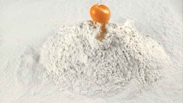 The super slow motion of the fresh egg falls into the pile of flour. Filmed on a high-speed camera at 1000 fps. — Stock Video