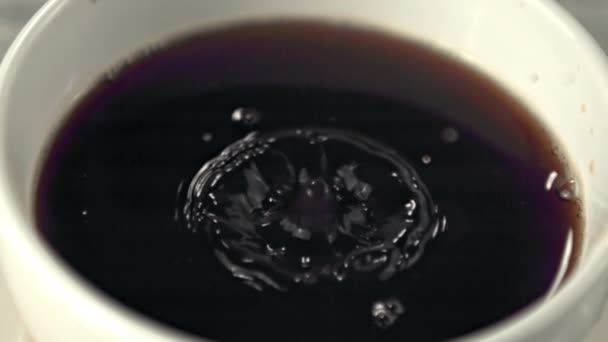 Super cámara lenta en la taza con café cae una gota con salpicaduras. Filmado en una cámara de alta velocidad a 1000 fps. — Vídeos de Stock