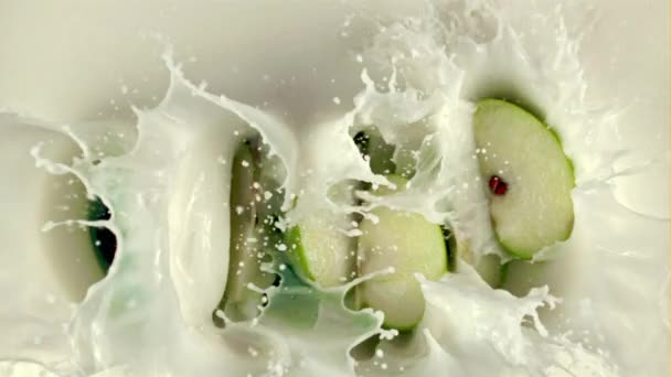 Супер повільний рух шматочків яблук потрапляють в молоко з бризками. Знято на високошвидкісній камері зі швидкістю 1000 к/с — стокове відео