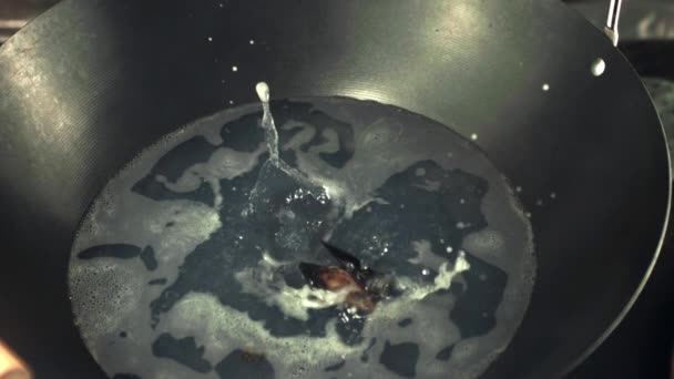Супер медленные мидии падают в горячую сковородку для приготовления пищи. Снято на высокоскоростную камеру со скоростью 1000 кадров в секунду. — стоковое видео