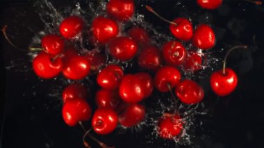 Süper yavaş çekimde olgun kiraz suya su sıçratarak düşer. 1000 fps hızla yüksek hızlı bir kamerayla çekildi..