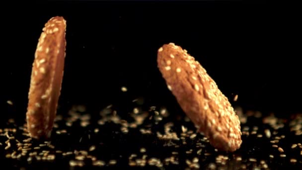 Galletas de avena fresca en cámara súper lenta con semillas de sésamo cae sobre la mesa. Filmado en una cámara de alta velocidad a 1000 fps. — Vídeo de stock