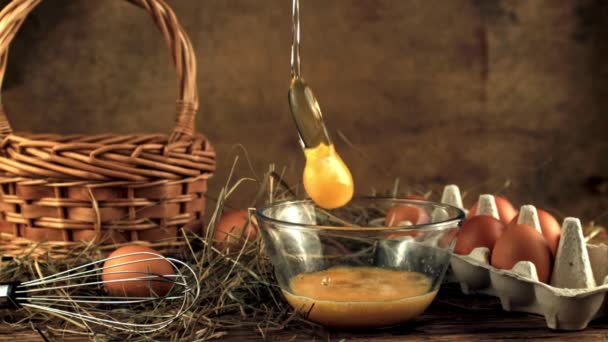 Super powolny ruch surowe jajko spada do miski z rozpryskami. Nagrywane na szybkiej kamerze z prędkością 1000 fps. — Wideo stockowe