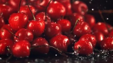 Kiraz damlayan bir yığın suyun üzerinde süper yavaş çekim. 1000 fps hızla yüksek hızlı bir kamerayla çekildi..