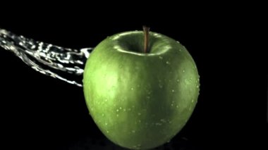 Süper yavaş çekim yeşil elma ve su damlaları. 1000 fps hızla yüksek hızlı kamera ile çekildi.