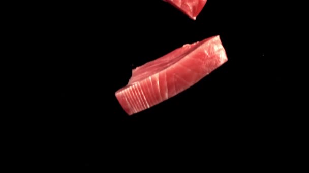 Super slow motion två rå tonfisk biffar faller på bordet med stänk av vatten. Inspelning på en höghastighetskamera vid 1000 fps. — Stockvideo
