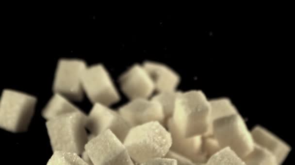 Super zpomalené kostky cukru stoupají a klesají. Natáčení na vysokorychlostní kameře při 1000 snímcích.Na černém pozadí. — Stock video