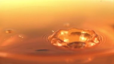 Süper yavaş çekim damlası su damlatarak elma suyuna düşer. 1000 fps hızla yüksek hızlı bir kamerayla çekildi..