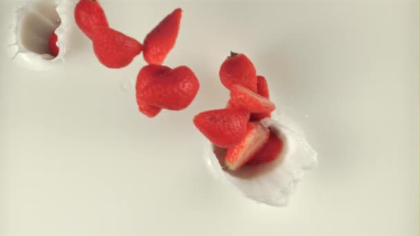 Σούπερ αργής κίνησης κομμάτια φράουλας πέφτουν στο γάλα. Τραβηγμένο σε κάμερα υψηλής ταχύτητας στα 1000 fps — Αρχείο Βίντεο