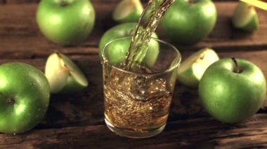Taze yeşil elmalardan süper yavaş çekim suyu bir bardak hava kabarcığına döküldü. 1000 fps hızla yüksek hızlı bir kamerayla çekildi..