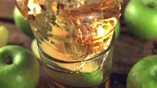 Супер замедленная съемка со спреем сбрасывает кусочек яблока в стакан сока. Снято на высокоскоростную камеру со скоростью 1000 кадров в секунду. — стоковое видео