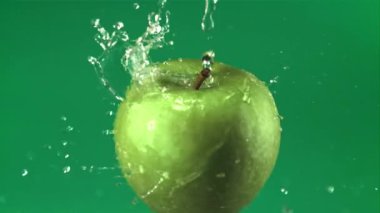 Süper yavaş çekimde su damlacıkları dönen taze bir elmanın üzerine düşer. 1000 fps hızla yüksek hızlı bir kamerayla çekildi.