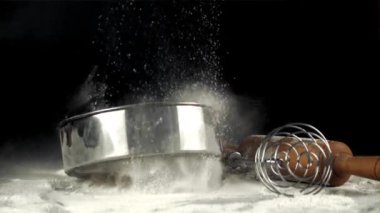 Süper yavaş çekim eleği un ve çırpma makinesiyle masaya düşer. 1000 fps hızla yüksek hızlı bir kamerayla çekildi..