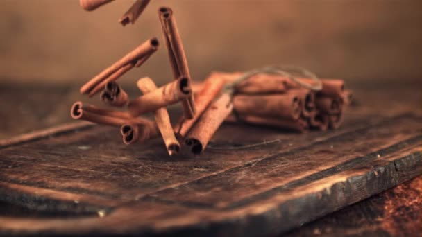 Super slow motion cinnamon sticks fall on a wooden cutting board. Filmed on a high-speed camera at 1000 fps. — Stock Video