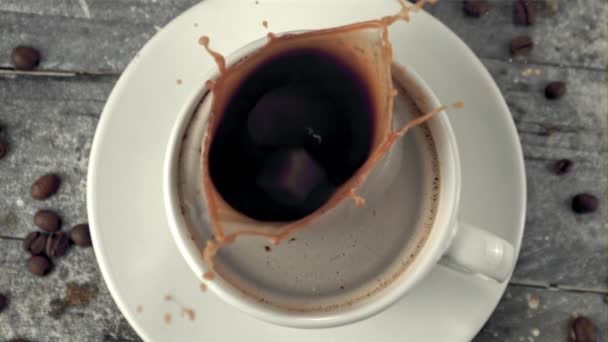 Una pieza de azúcar en cámara súper lenta cae en el café con salpicaduras. Filmado en una cámara de alta velocidad a 1000 fps. — Vídeos de Stock