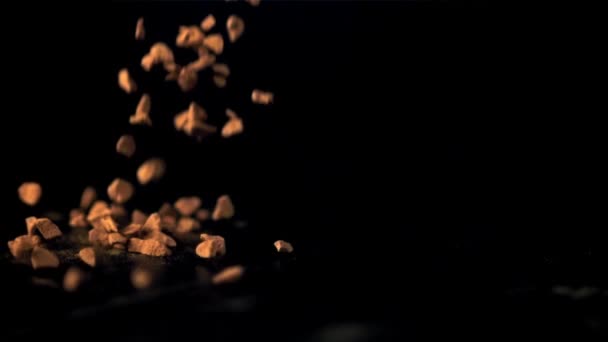 Pellets de café solubles en cámara súper lenta caen sobre la mesa. Filmado en una cámara de alta velocidad a 1000 fps. — Vídeo de stock