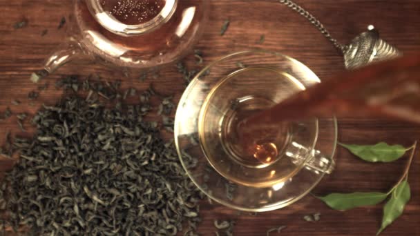 Um jato super lento de chá perfumado derrama com salpicos na xícara. Filmado em uma câmera de alta velocidade a 1000 fps. — Vídeo de Stock