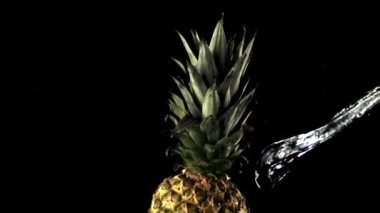 Dönen bir ananasın üzerinde süper yavaş çekim bir su jeti düşürür. 1000 fps hızla yüksek hızlı bir kamerayla çekildi..