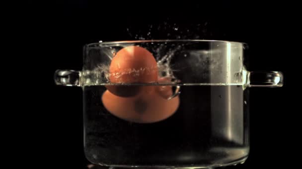 Super slow motion eieren vallen in een pot water. Gefilmd op een hoge snelheidscamera met 1000 fps. — Stockvideo