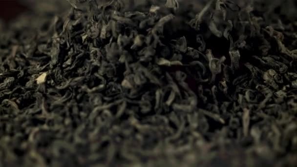 Super powolne kawałki sucha herbata podnoszenia i upadku. Nagrywane na szybkiej kamerze z prędkością 1000 fps. — Wideo stockowe