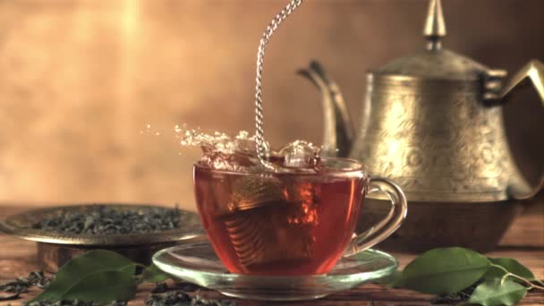 Super-Zeitlupe in einer Tasse Tee tropft ein Sieb mit Spritzern. Gefilmt mit einer Hochgeschwindigkeitskamera bei 1000 fps. — Stockvideo
