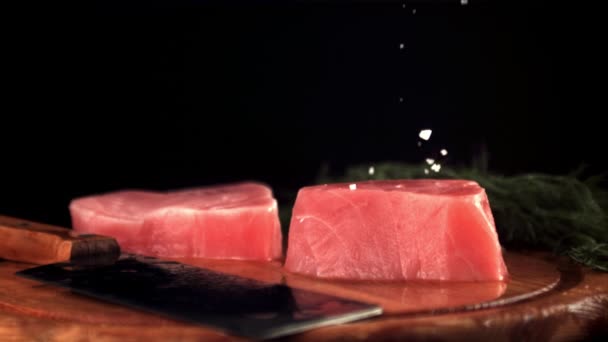 Super cámara lenta en filetes de atún crudo cae sal. Filmado en una cámara de alta velocidad a 1000 fps. — Vídeo de stock