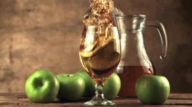 Süper yavaş çekimde bir elma parçası bir bardak elma suyuna düşer. 1000 fps hızla yüksek hızlı bir kamerayla çekilir..