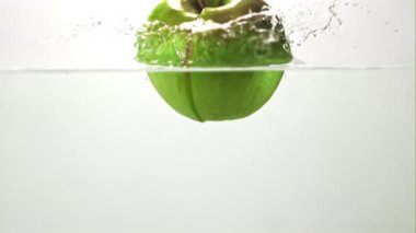 Süper yavaş çekimde sulu elma suya su sıçramasıyla düşer. 1000 fps hızla yüksek hızlı bir kamerayla çekildi..