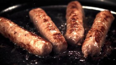 Süper yavaş çekimde sosisler kızartma tavasında kızartılır ve yağ damlatırlar. 1000 fps hızla yüksek hızlı bir kamerayla çekildi..