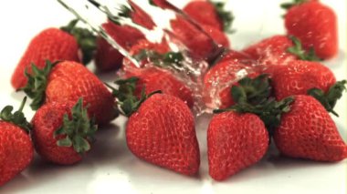 Çileklerin üzerinde süper yavaş çekim suyu döker. 1000 fps hızla yüksek hızlı bir kamerayla çekildi.