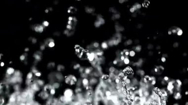 Su damlacıkları siyah arka planda yükselir ve düşer. 1000 fps 'de yüksek hızlı bir kamerayla çekildi. Yüksek kaliteli FullHD görüntüler